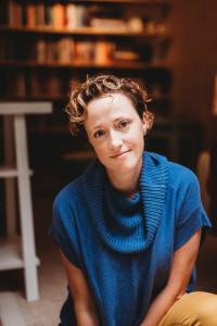 Keetje Kuipers Photo of a woman with short, curly hair wearing a blue sweater