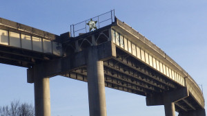 Looking up at the end of a motorway, with the Self Help Radio logo on the fence at the end.